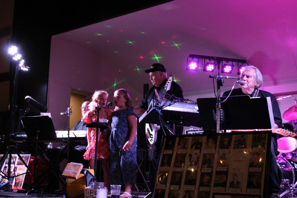 Two little girls join The Senders on stage for one of their songs.