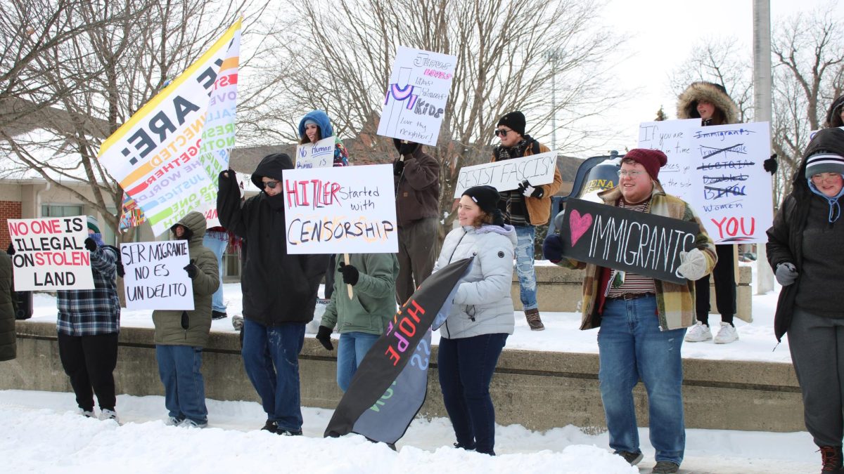 Student protesters hold signs by the Victory Bell in a campus protest on February 16, 2025.