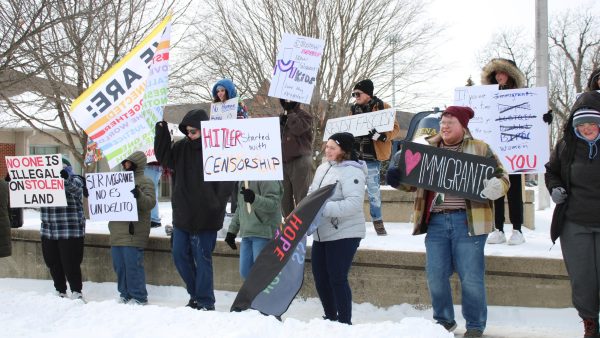 Student protesters hold signs by the Victory Bell in a campus protest on February 16, 2025.