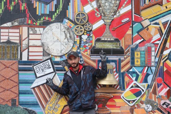 Octavio Olvera points to the two changes on the mural. 